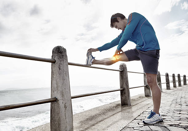 Shot of a young man stretching his leg before a run