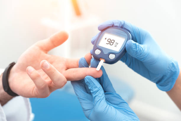 Doctor checking blood sugar level with a glucometer, illustrating the treatment and management of diabetes.