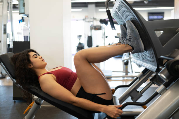 Young woman doing leg presses, a beneficial exercise for managing arthritis in knee.