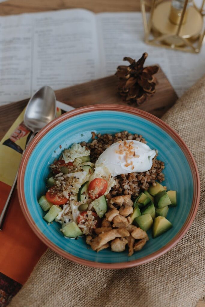 A bowl of food with avocado, eggs and nuts