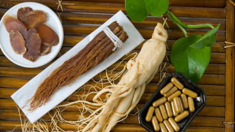 Ginseng supplements in a bottle with a fresh ginseng plant placed beside it. Natural adaptogen for energy, stress relief, immune support, and cognitive health.